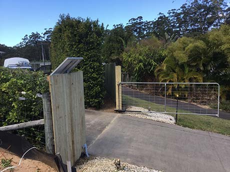 Solar powered swing gate open over driveway